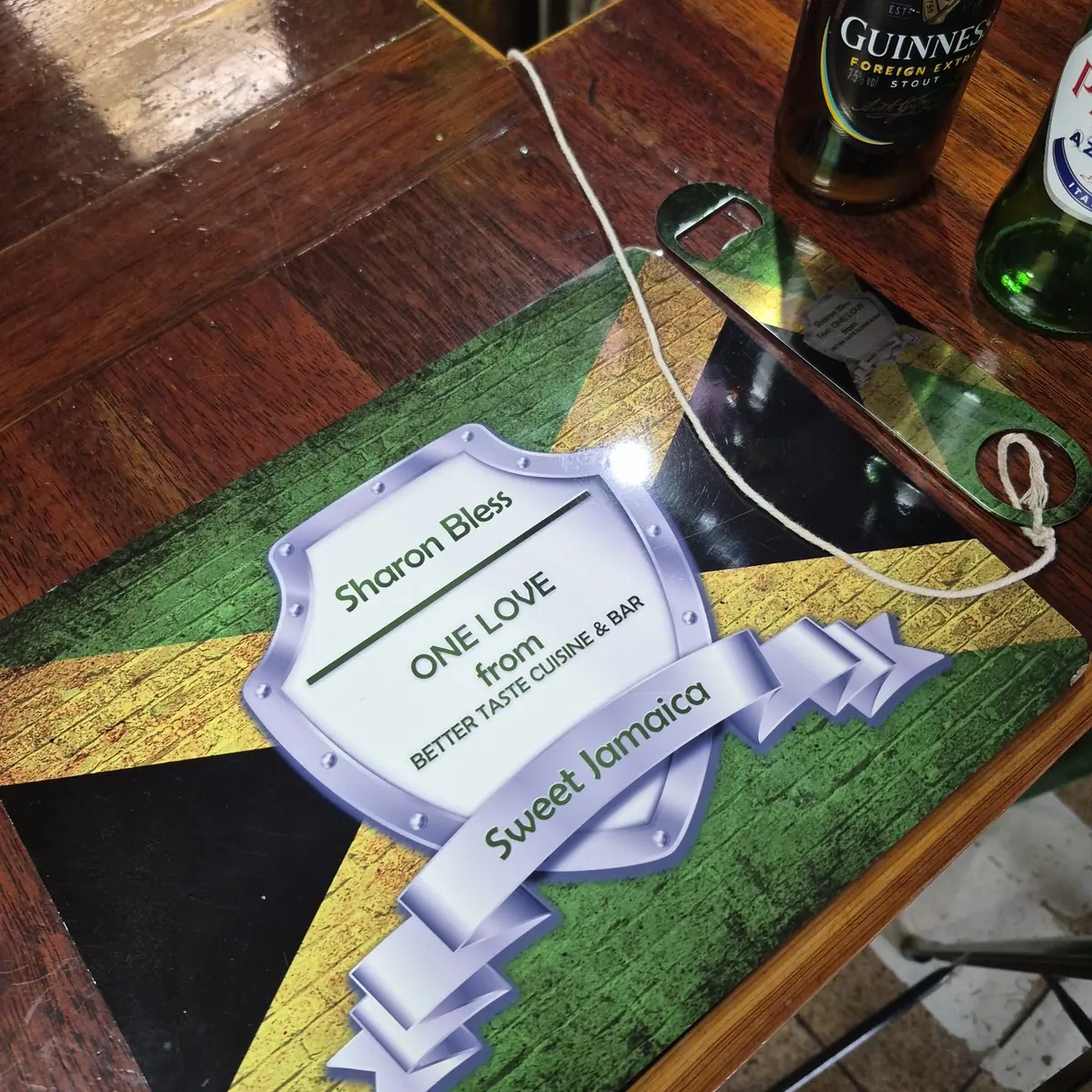 A Jamaican-flag-painted table top with bottles of Guinness and beer